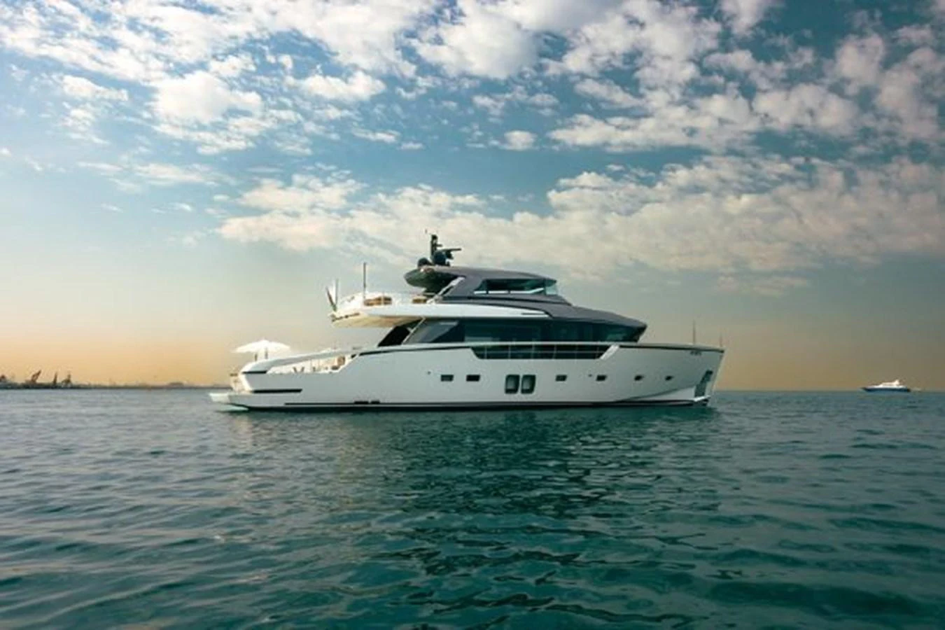 A sleek and modern yacht cruises gracefully on calm waters under a picturesque sky. aboard FOUZ Yacht for Sale