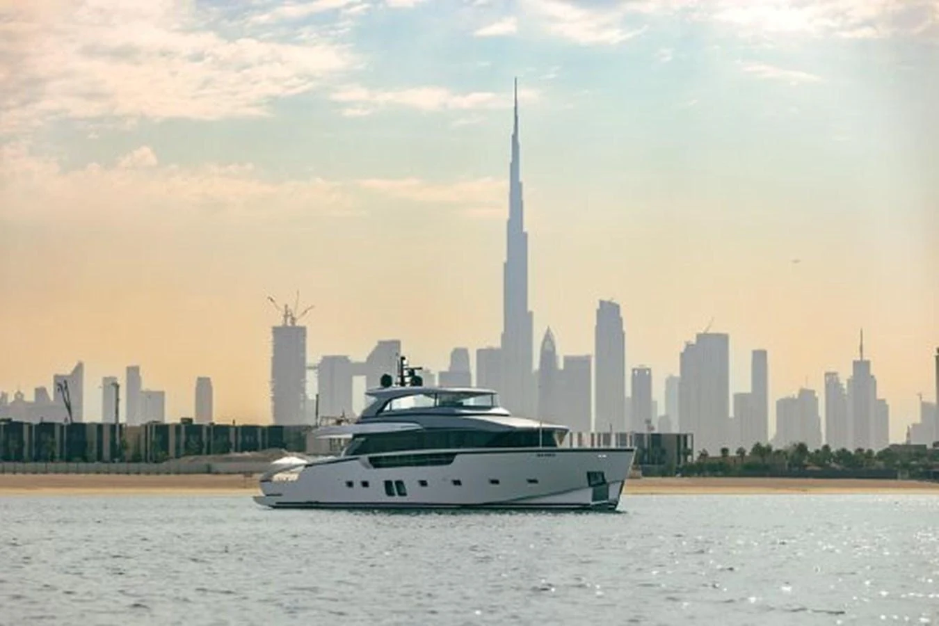 A sleek yacht cruises against a stunning city skyline backdrop. aboard FOUZ Yacht for Sale