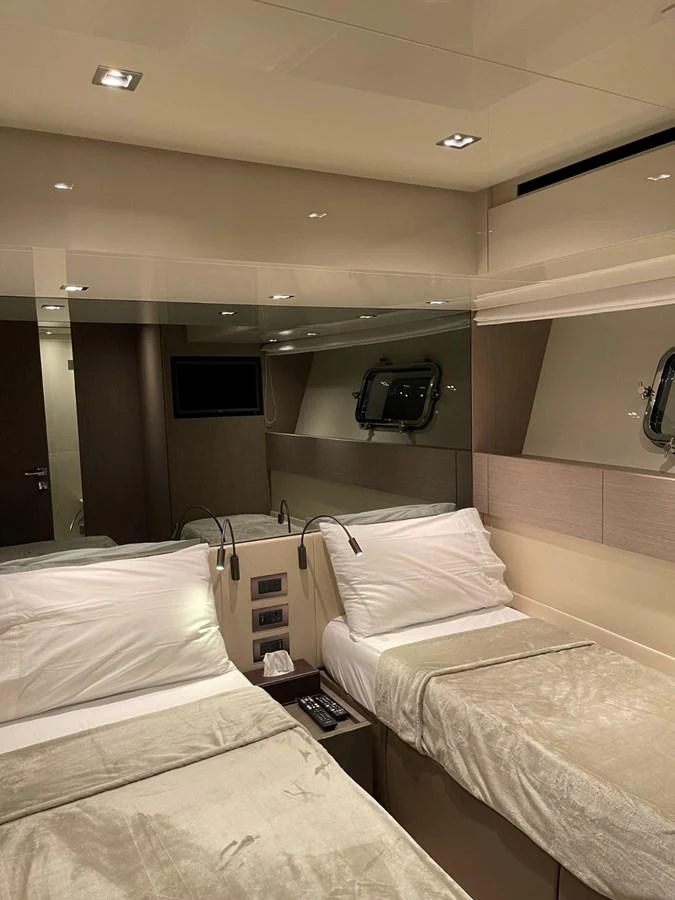 The stateroom features twin beds with luxurious linens and modern lighting. aboard FOUZ Yacht for Sale