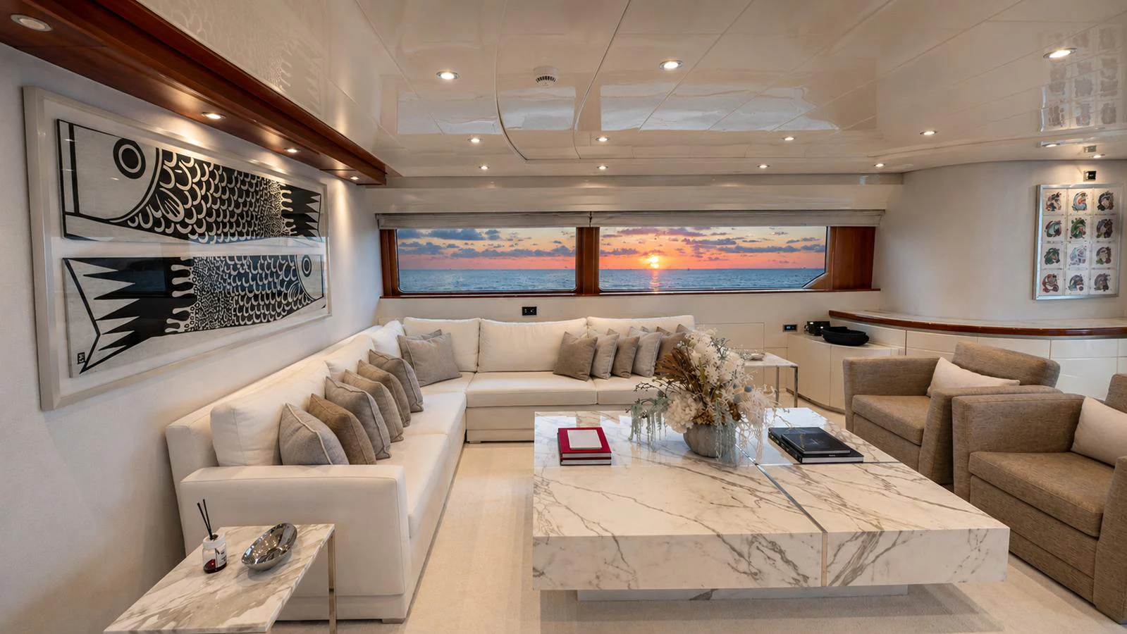 The salon features a luxurious seating area with a stunning sunset view through large windows. aboard ALPHERATZ Yacht for Sale