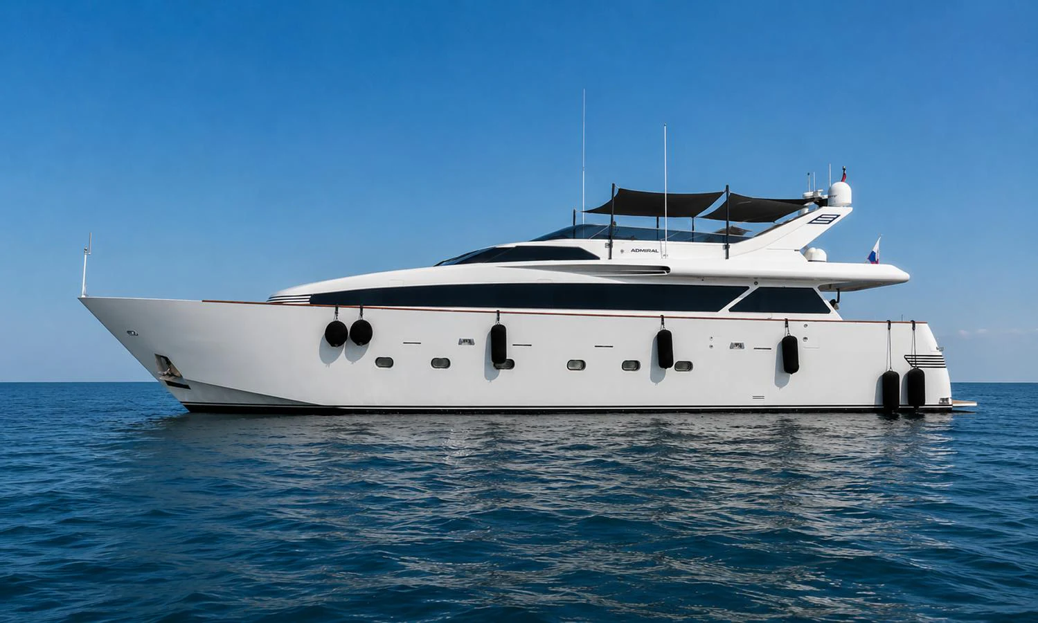 A sleek and modern yacht glides gracefully on calm waters under a clear blue sky. aboard ALPHERATZ Yacht for Sale