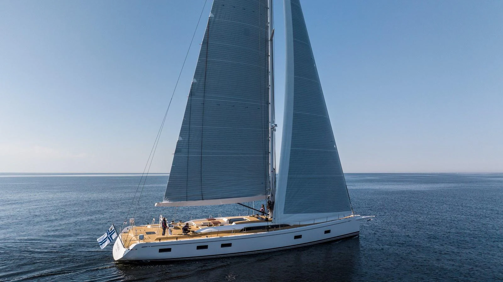 A sleek sailing yacht glides gracefully on calm waters under clear skies. aboard DREAMCATCHER Yacht for Sale