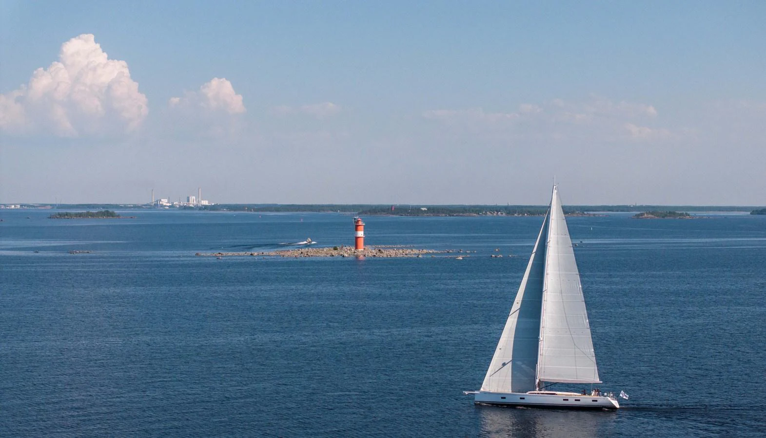 A sleek sailing yacht glides gracefully across the calm blue waters under a clear sky. aboard DREAMCATCHER Yacht for Sale