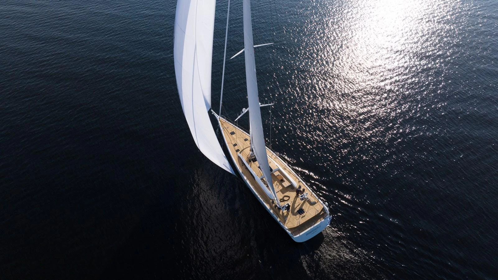 A sleek sailing yacht glides gracefully over calm waters, its sails billowing in the wind. aboard DREAMCATCHER Yacht for Sale