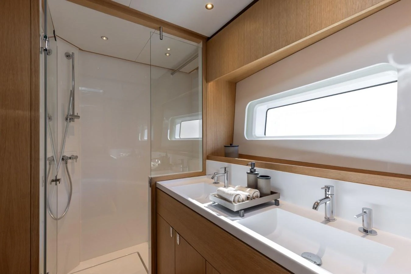 The yacht's bathroom features a sleek design with a spacious shower and double sinks. aboard DREAMCATCHER Yacht for Sale