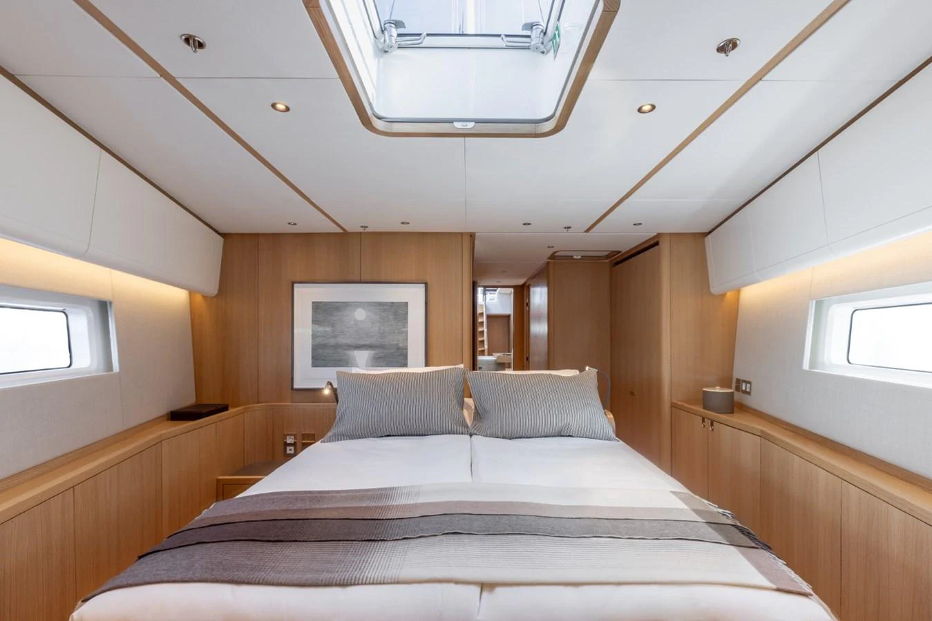 The stateroom features a spacious bed with modern, minimalist decor and ample natural light. aboard DREAMCATCHER Yacht for Sale