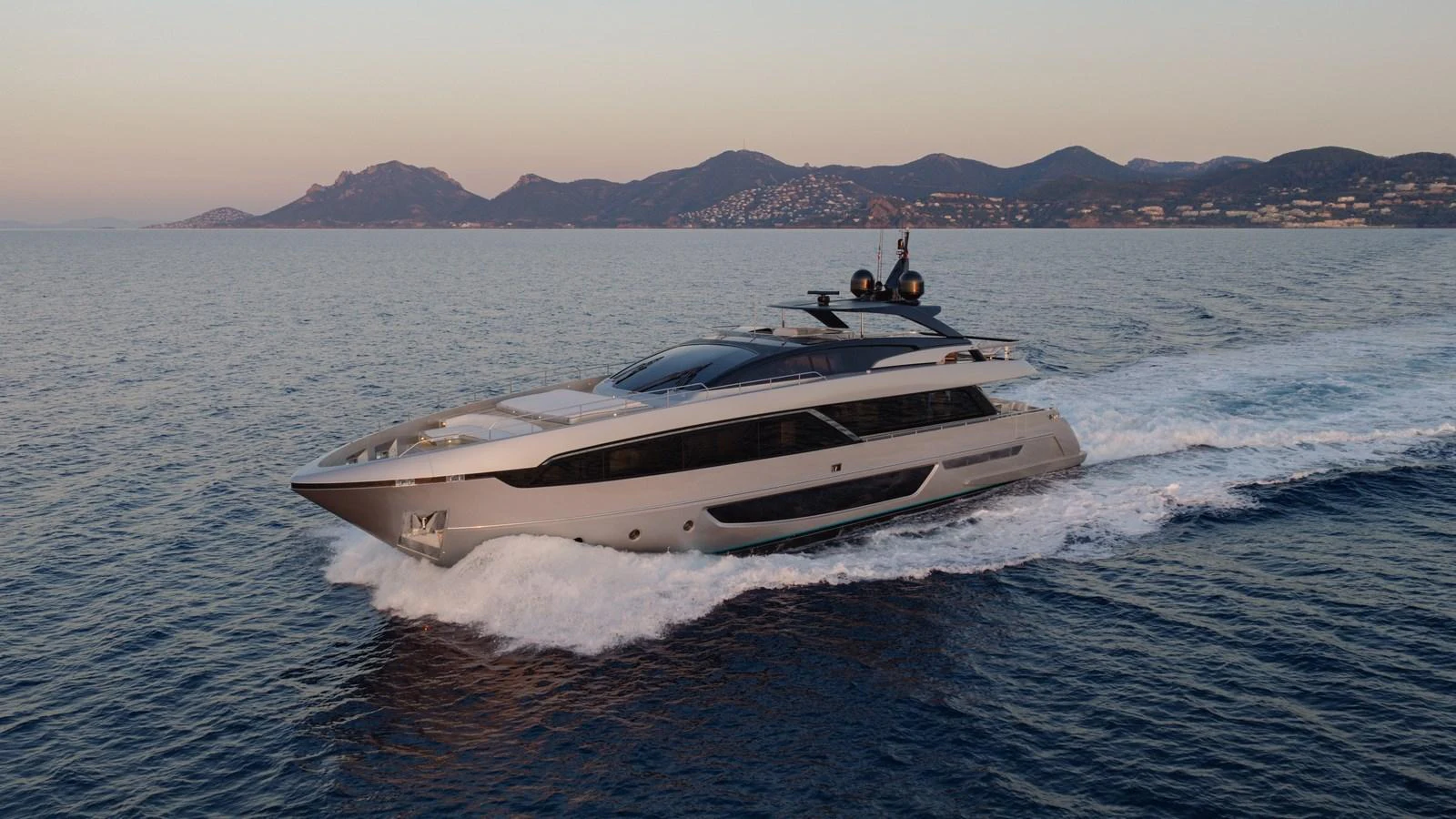 A sleek and modern yacht cruises through calm waters with a stunning coastal backdrop. aboard M Yacht for Sale