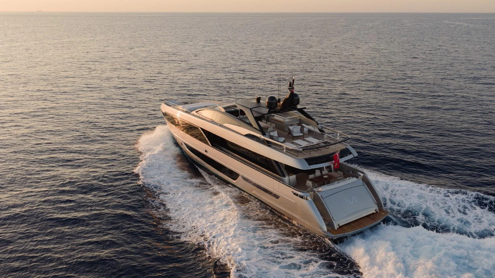 A sleek and modern yacht cruises through the open sea at sunset. aboard M Yacht for Sale