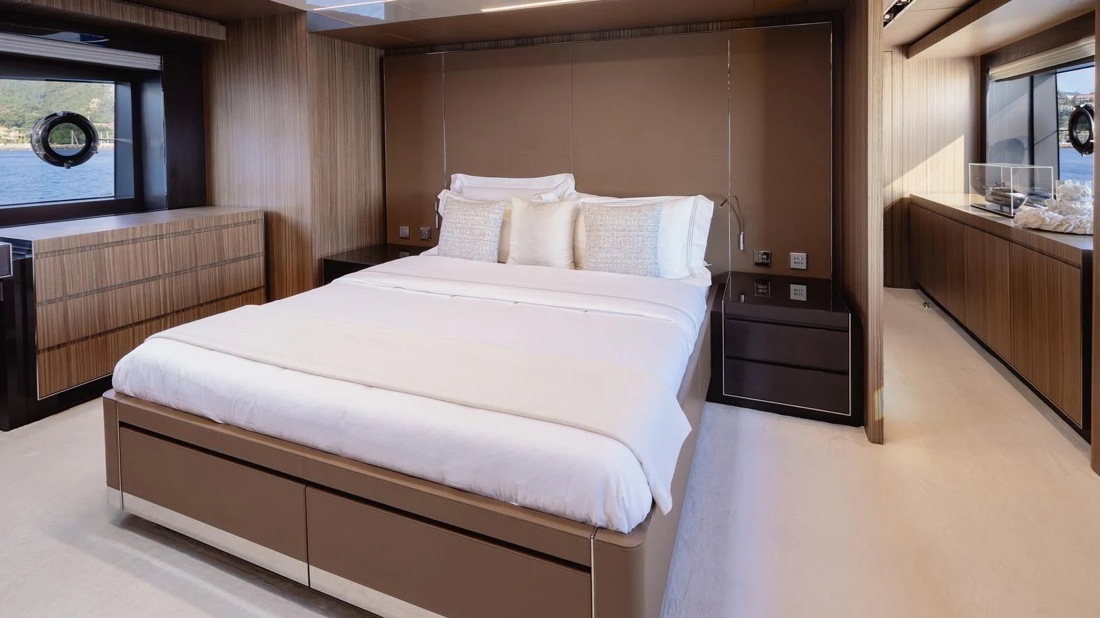 The master stateroom features a luxurious bed with elegant wood paneling and large windows offering scenic views. aboard M Yacht for Sale