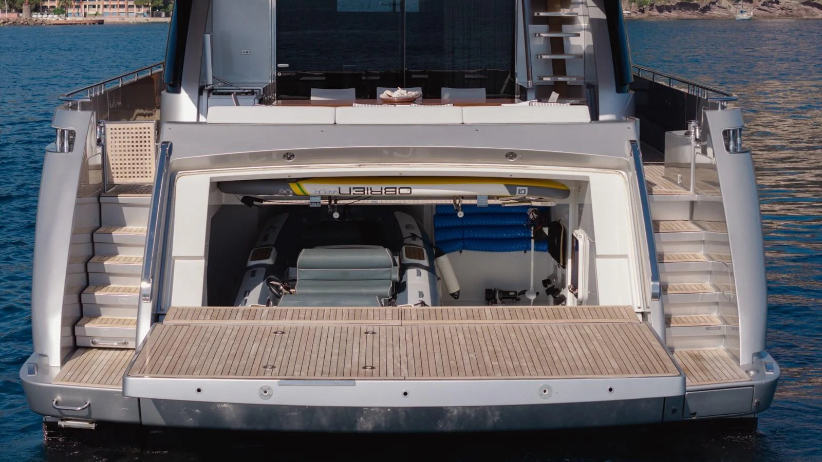 The yacht's garage is open, revealing a neatly stored tender and water sports equipment. aboard M Yacht for Sale