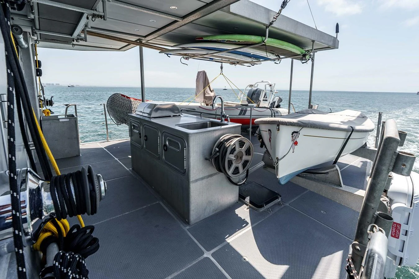 The aft deck features a practical setup with water sports equipment and storage solutions. aboard UGLY BETTY Yacht for Sale