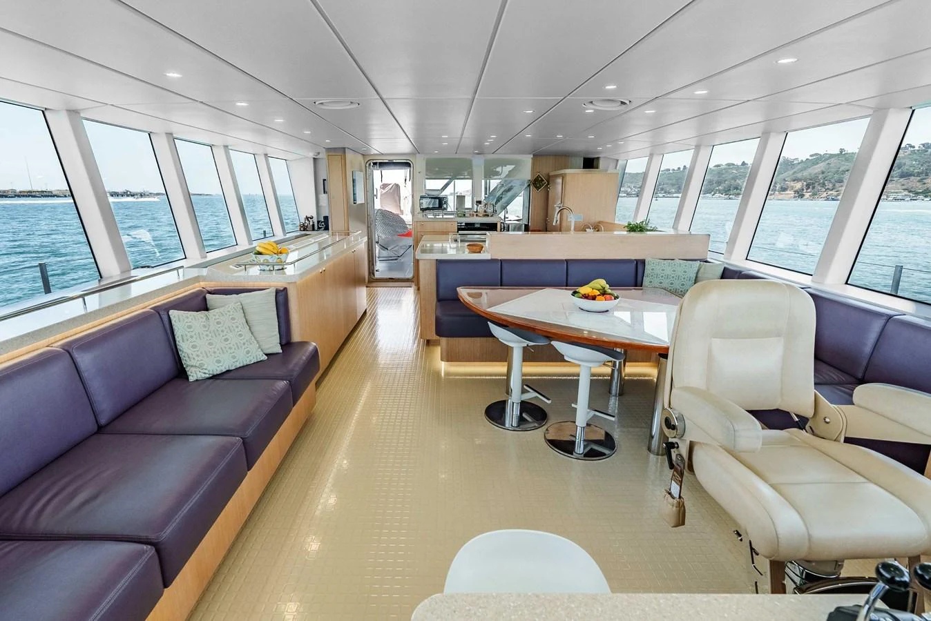 The salon features ample seating with panoramic windows offering stunning ocean views. aboard UGLY BETTY Yacht for Sale