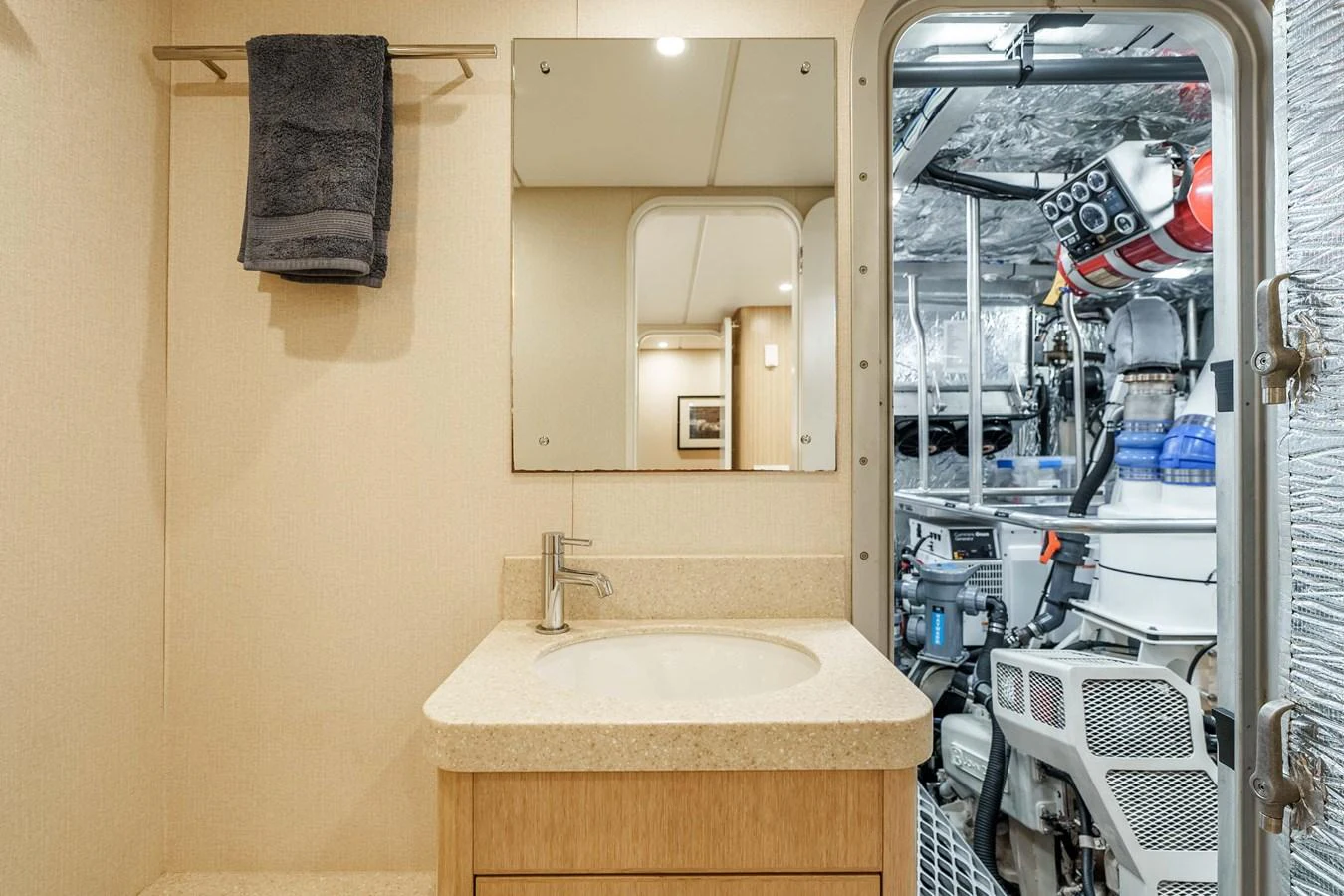 A compact yacht bathroom with a view into the engine room. aboard UGLY BETTY Yacht for Sale