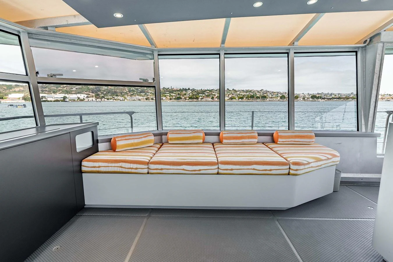 The salon features a comfortable seating area with large windows offering panoramic views of the water. aboard UGLY BETTY Yacht for Sale