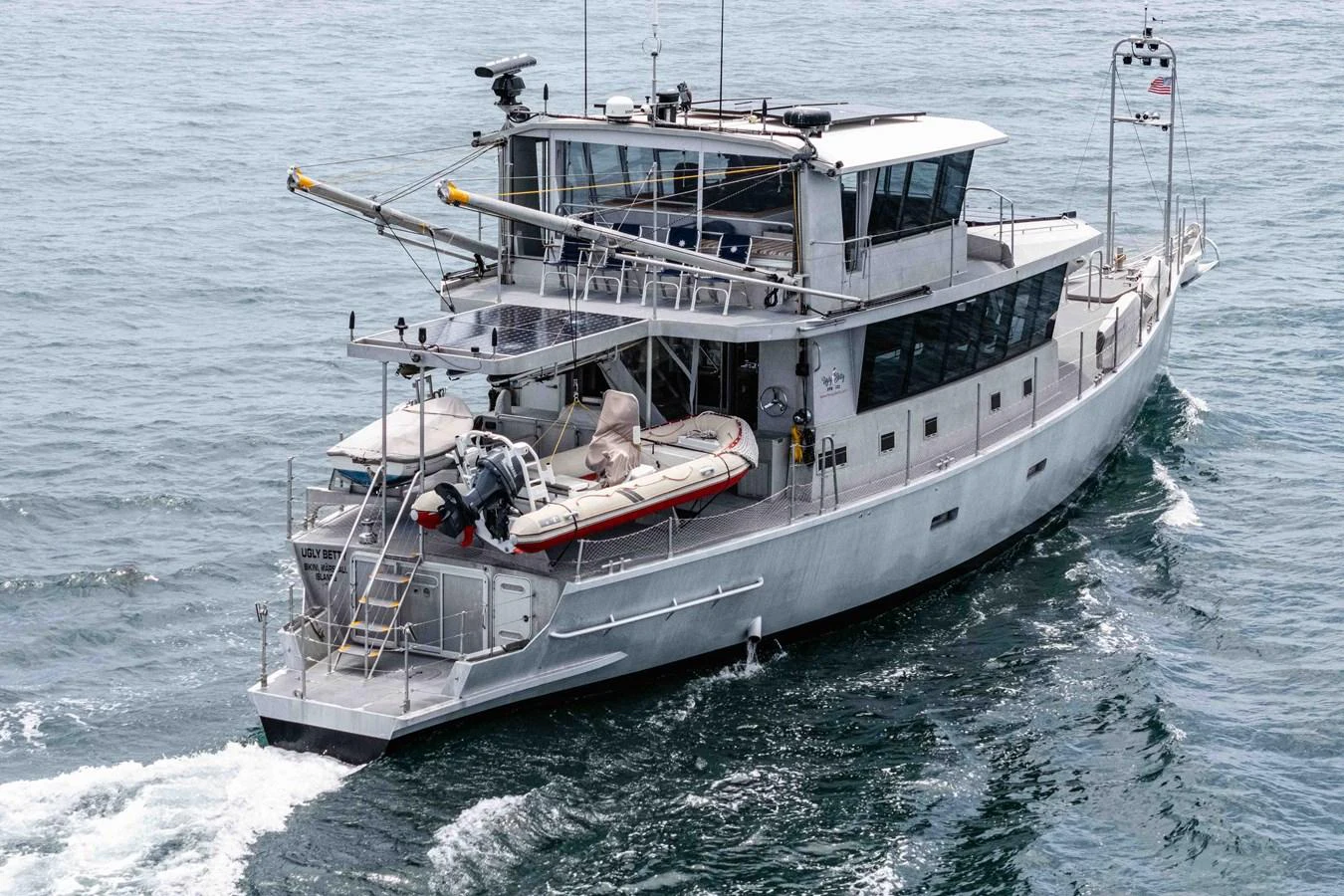 A robust yacht navigates through calm waters, showcasing its sturdy design and ample deck space. aboard UGLY BETTY Yacht for Sale
