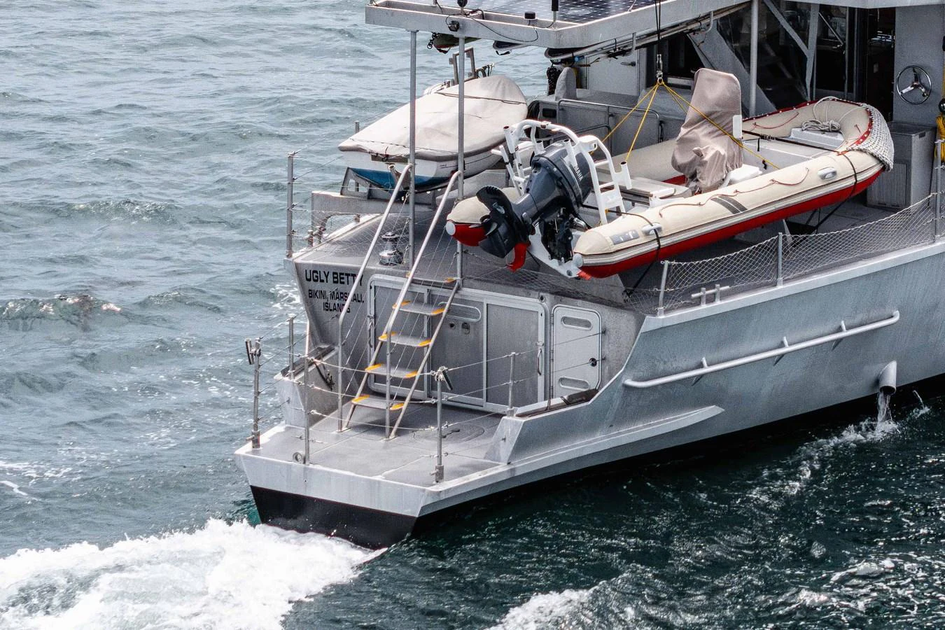 The aft deck of the yacht features a tender and various equipment, showcasing its readiness for adventure. aboard UGLY BETTY Yacht for Sale