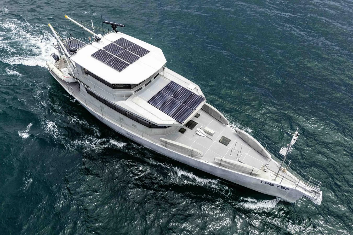 A sleek yacht with solar panels glides through the water, showcasing its modern design. aboard UGLY BETTY Yacht for Sale
