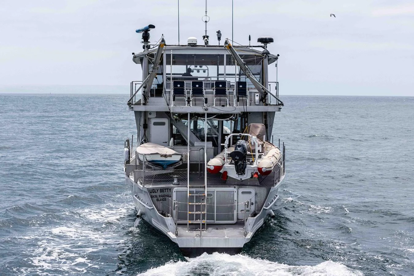 The yacht is seen from the rear, showcasing its robust structure and various equipment on board. aboard UGLY BETTY Yacht for Sale