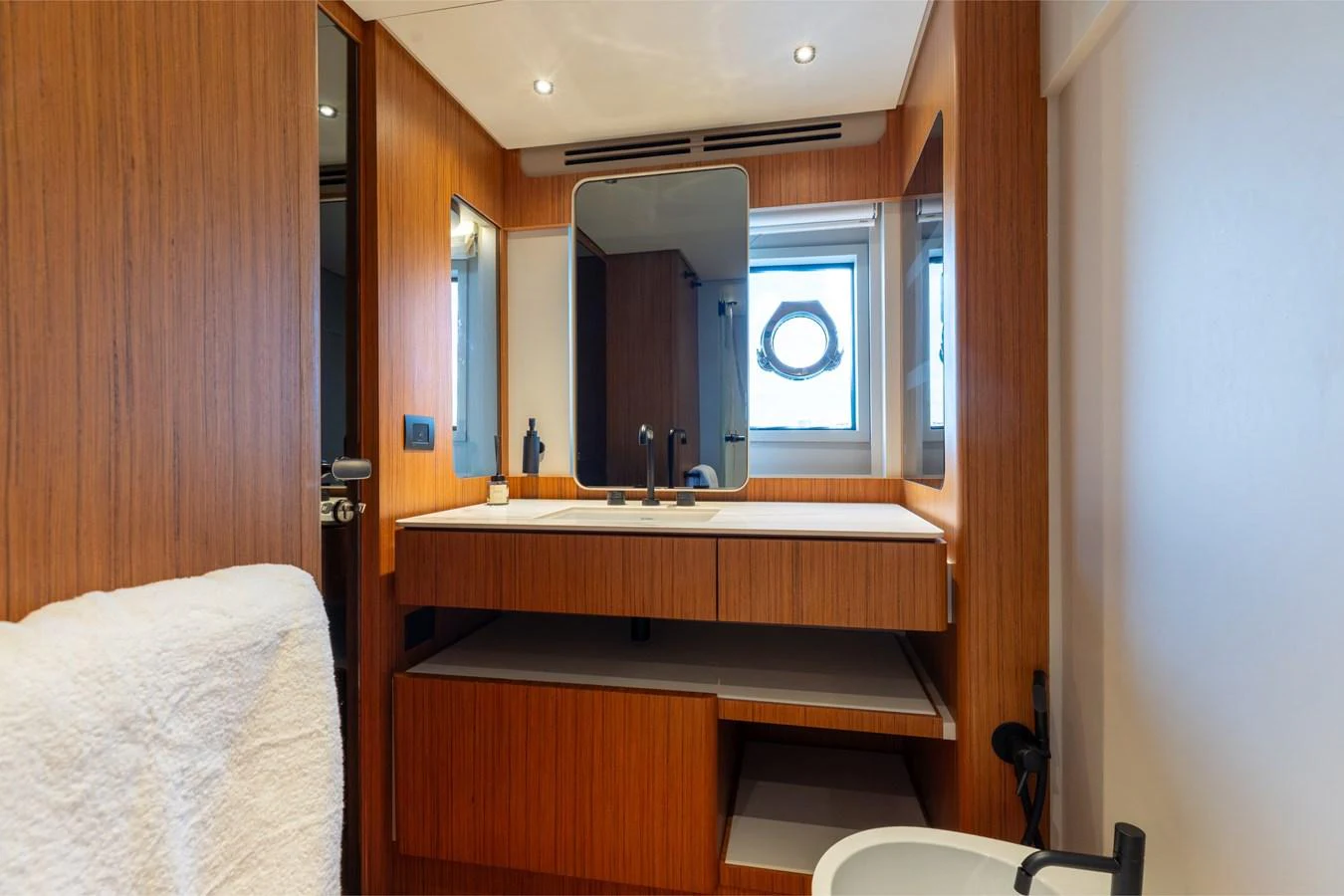 The yacht's bathroom features modern wood paneling and a sleek vanity area. aboard KATRIN I Yacht for Sale