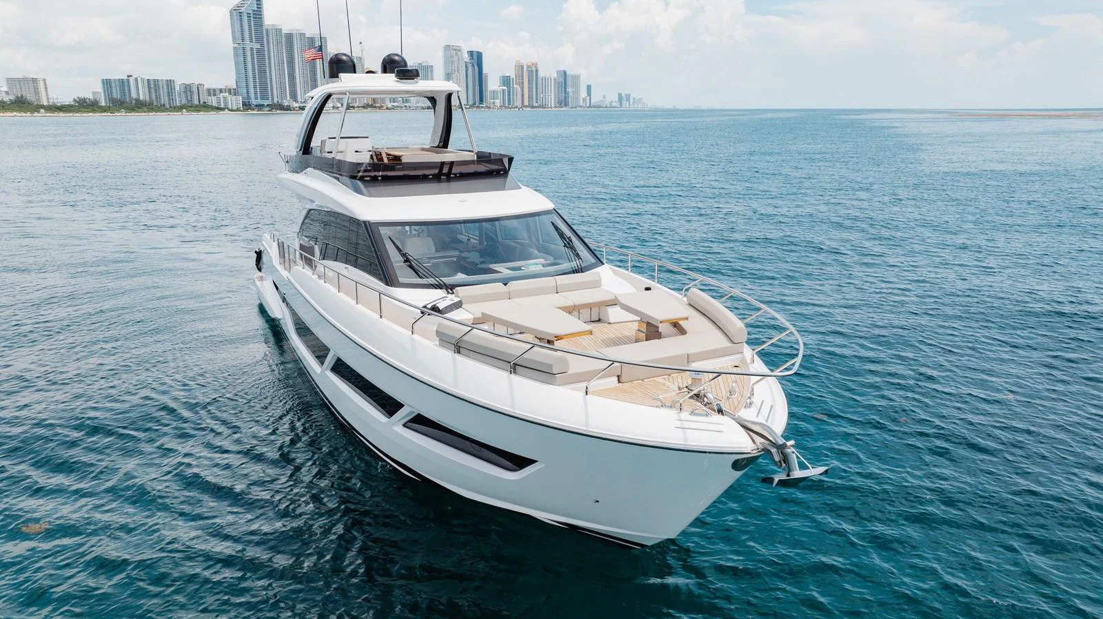 A sleek and modern yacht cruising on calm waters with a city skyline in the background. aboard KATRIN I Yacht for Sale