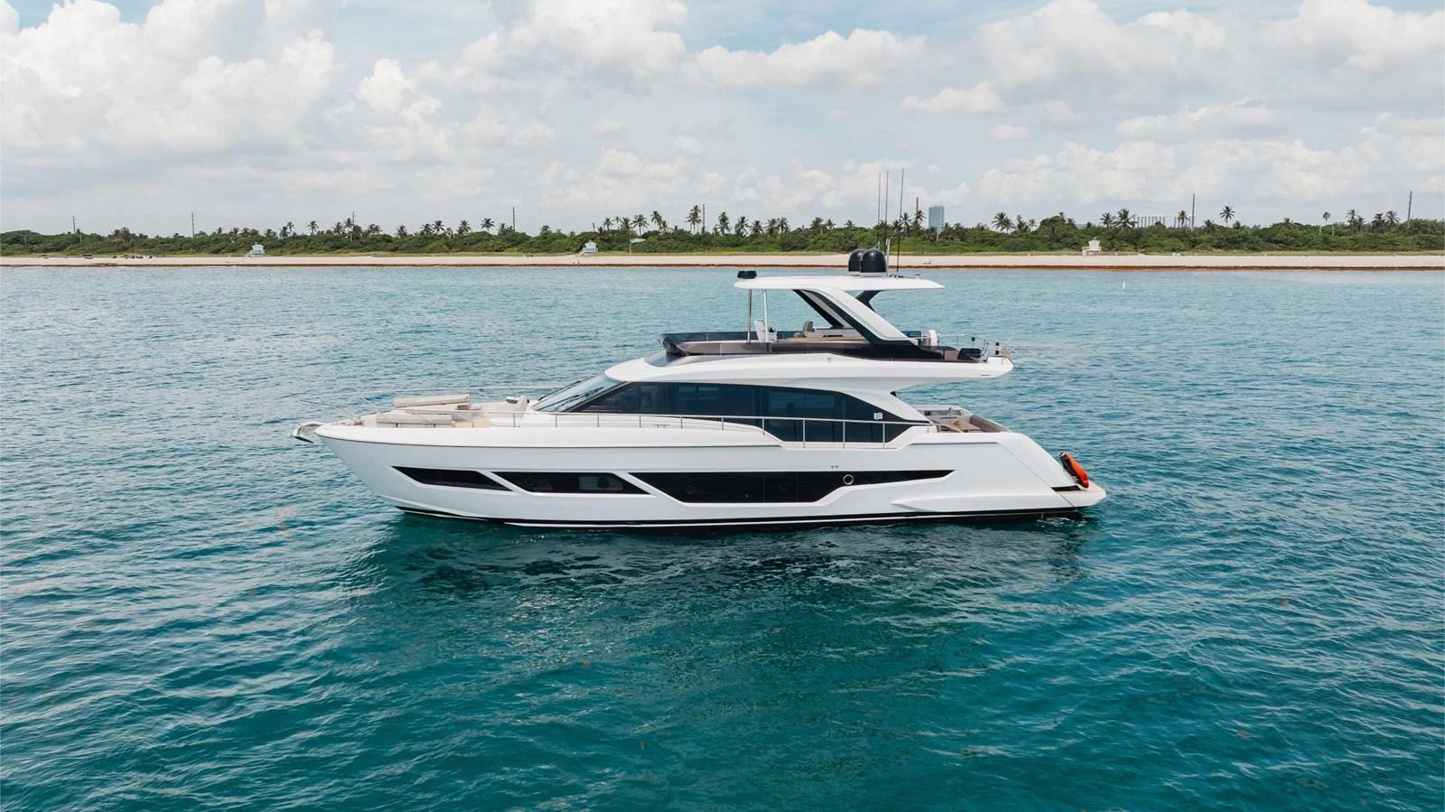 A sleek and modern yacht cruises gracefully on calm waters near a scenic coastline. aboard KATRIN I Yacht for Sale