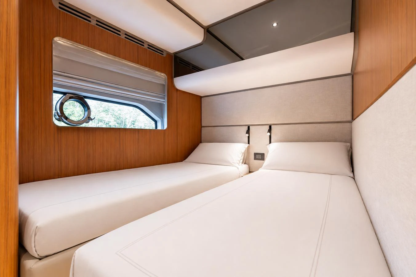 The twin stateroom offers a cozy and modern sleeping area with two single beds and elegant wood paneling. aboard KATRIN I Yacht for Sale