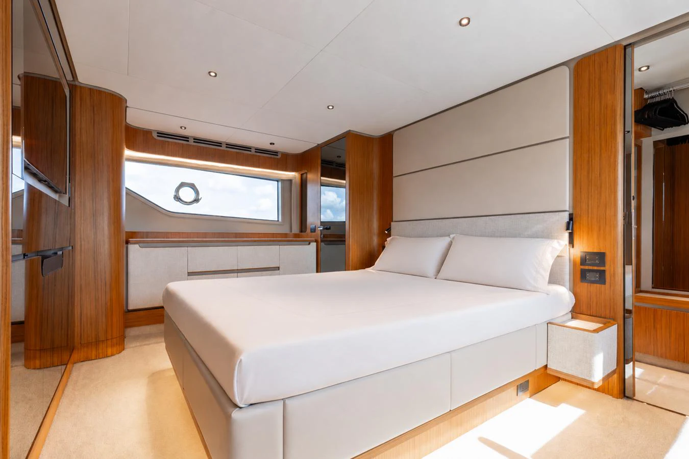 The master stateroom features a spacious bed with elegant wood accents and ample natural light. aboard KATRIN I Yacht for Sale