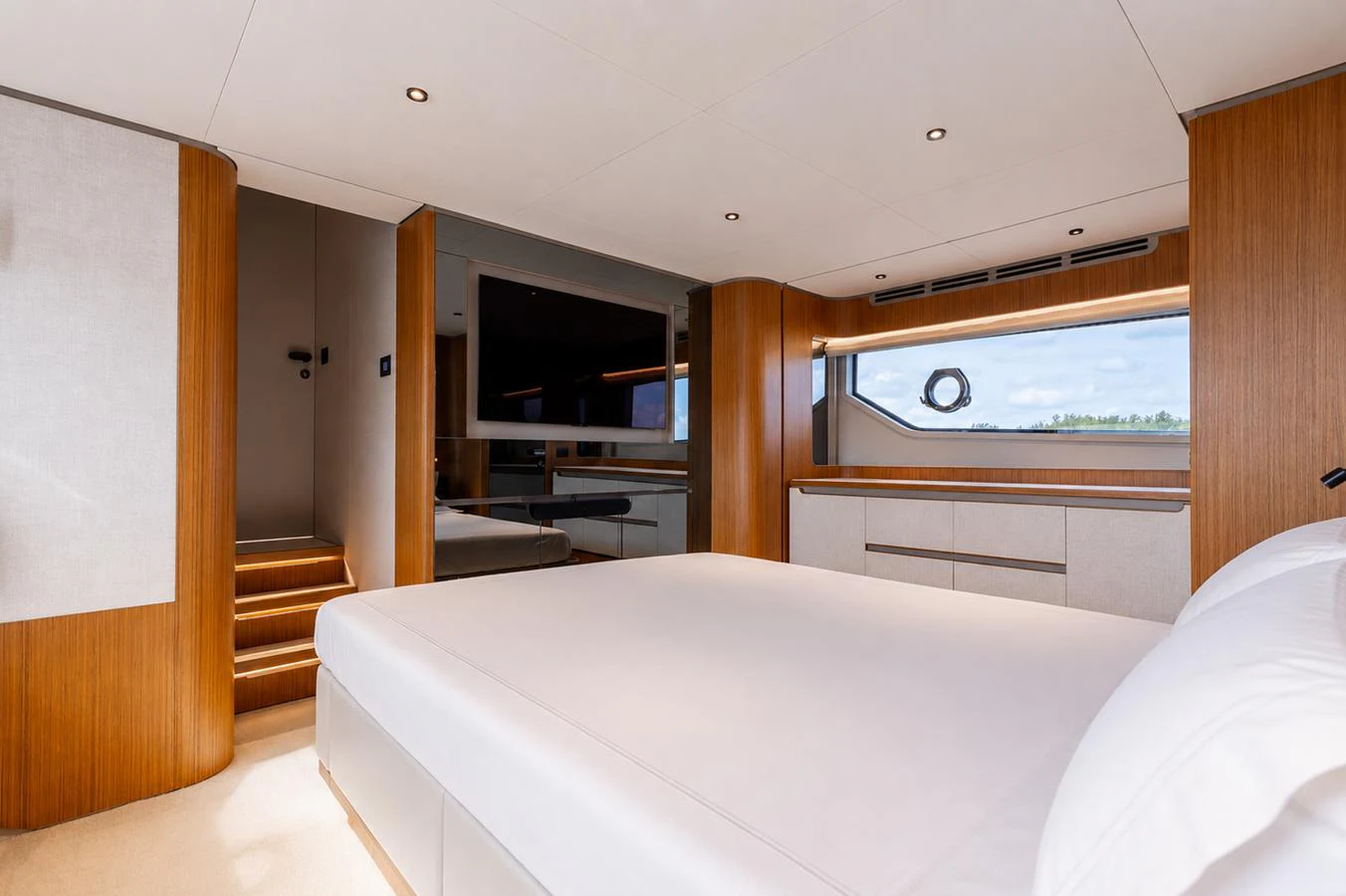 This elegant stateroom features a large bed, modern wood finishes, and ample natural light from the window. aboard KATRIN I Yacht for Sale