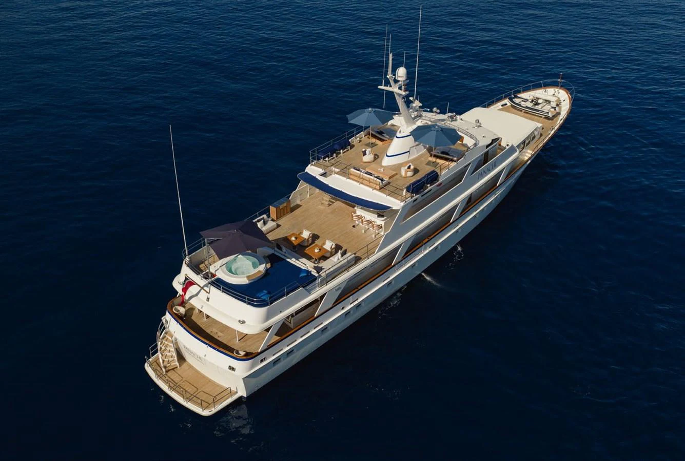 A luxurious yacht cruising on calm blue waters, showcasing its expansive decks and elegant design. aboard PANACHE Yacht for Sale