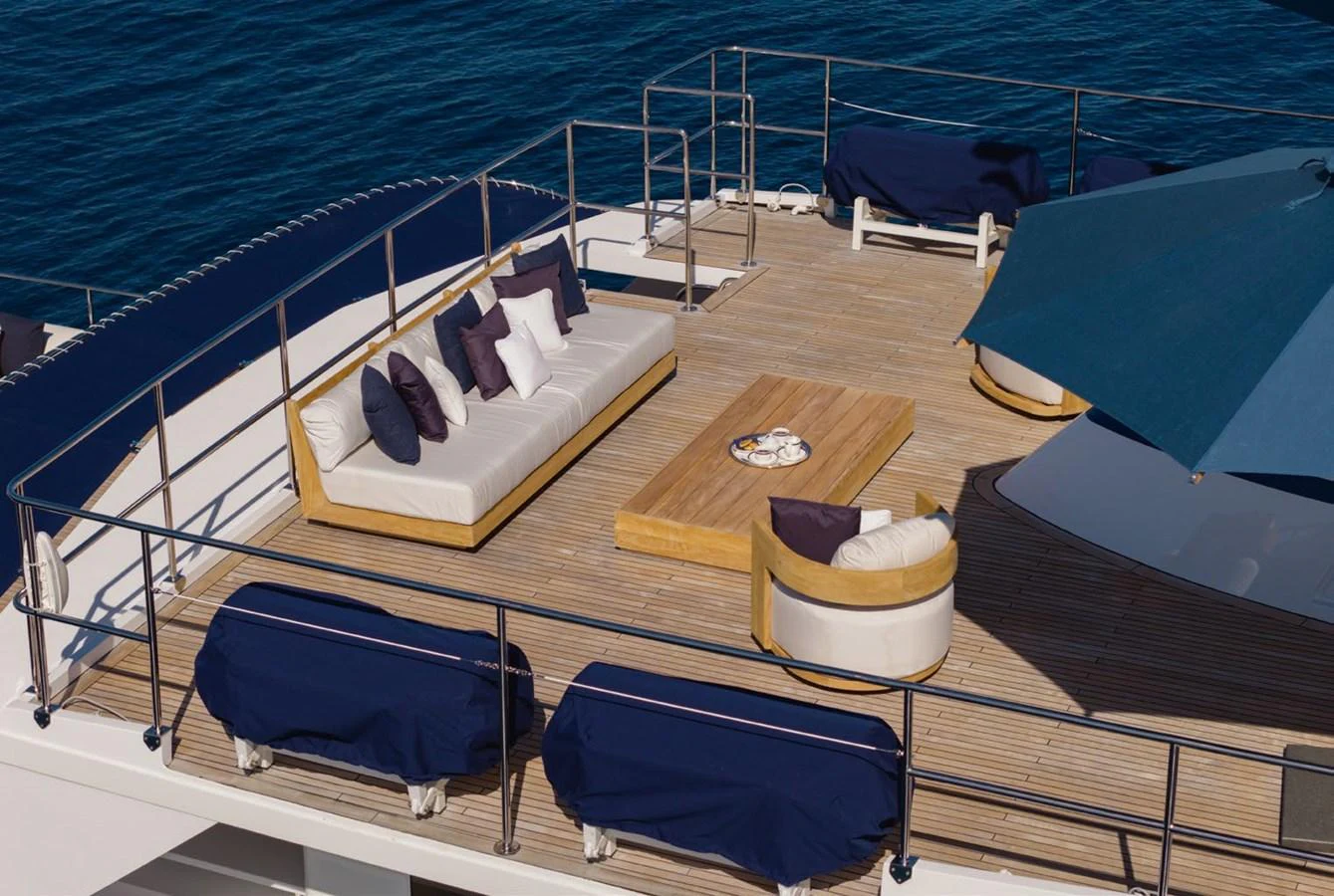 The sundeck offers a luxurious lounging area with comfortable seating and a large umbrella for shade. aboard PANACHE Yacht for Sale