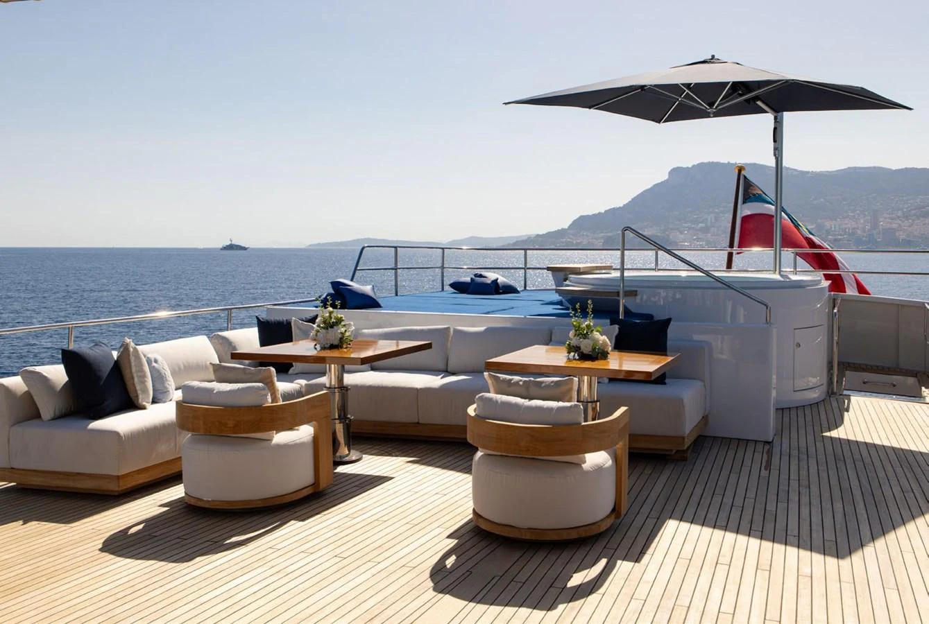 The sundeck offers a luxurious lounging area with comfortable seating, tables, and a large parasol, perfect for relaxation and enjoying the view. aboard PANACHE Yacht for Sale