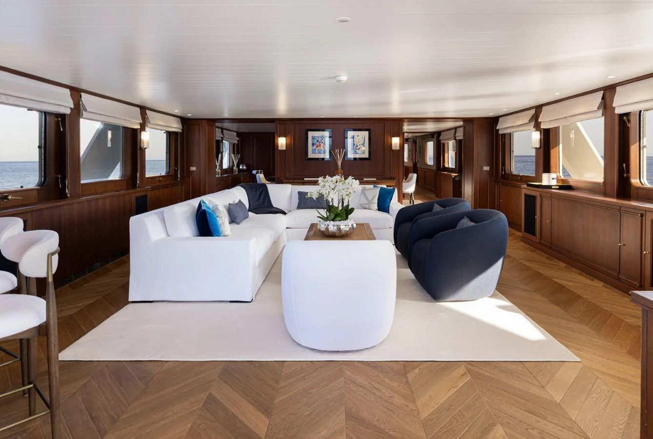 The spacious salon features elegant seating and large windows offering stunning ocean views. aboard PANACHE Yacht for Sale
