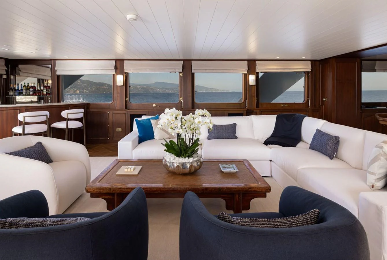 The salon features a spacious seating area with plush sofas and a panoramic view through large windows. aboard PANACHE Yacht for Sale