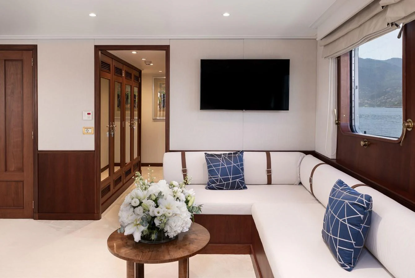 A stylish and comfortable interior lounge area with a large window offering scenic views. aboard PANACHE Yacht for Sale