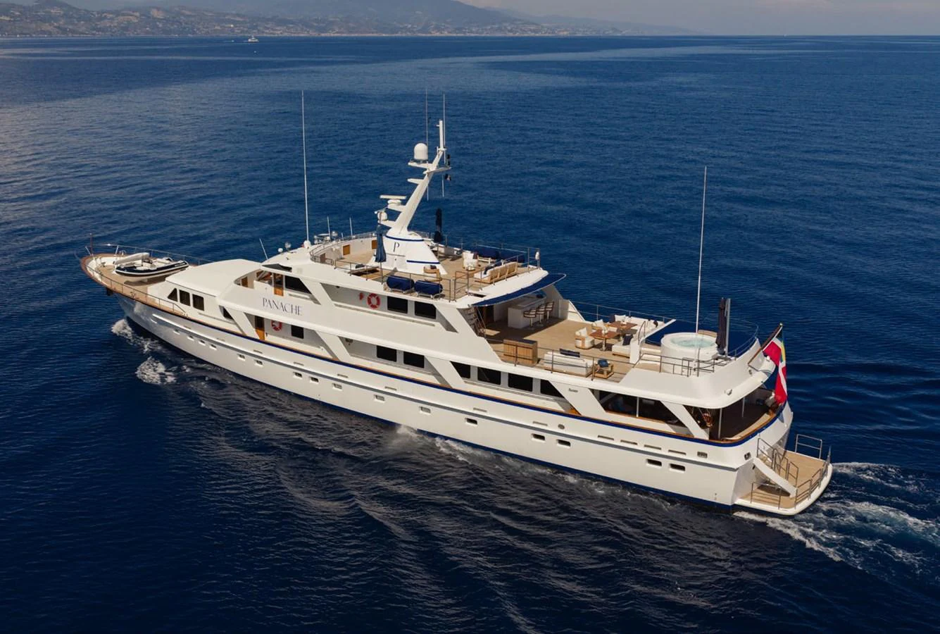 A luxurious yacht cruises through calm blue waters, showcasing its elegant design and spacious decks. aboard PANACHE Yacht for Sale