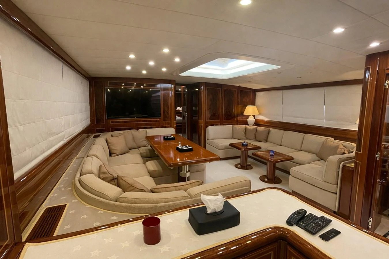 The salon features plush seating and elegant wood finishes, creating a warm and inviting atmosphere. aboard ANGELINA Yacht for Sale