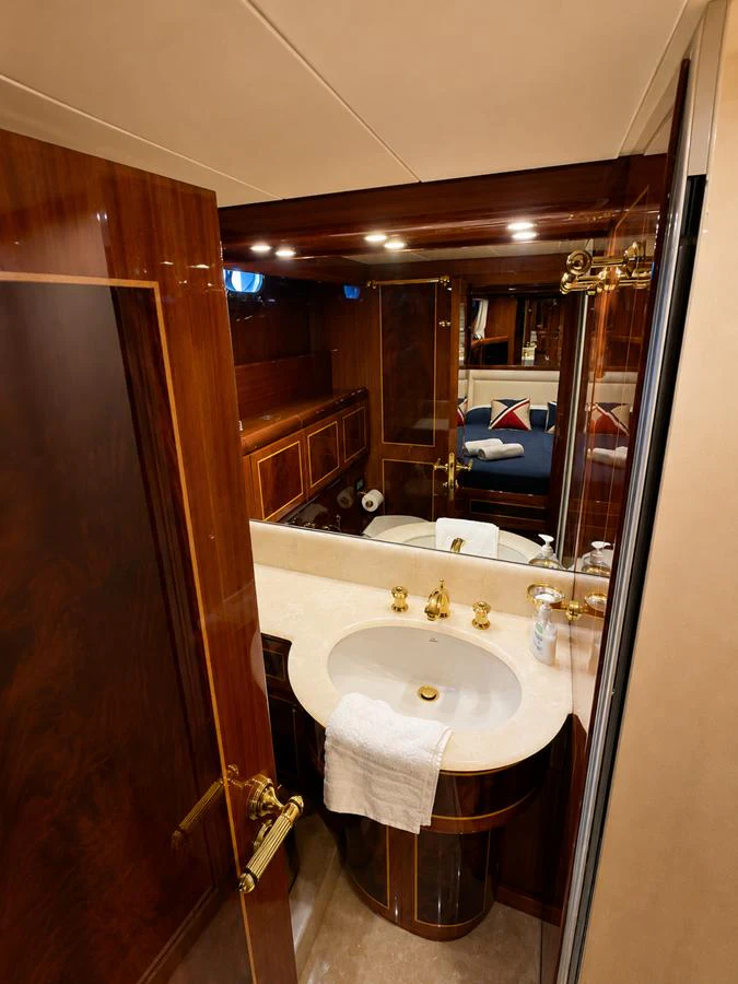 A luxurious bathroom with elegant wood finishes and gold fixtures. aboard ANGELINA Yacht for Sale