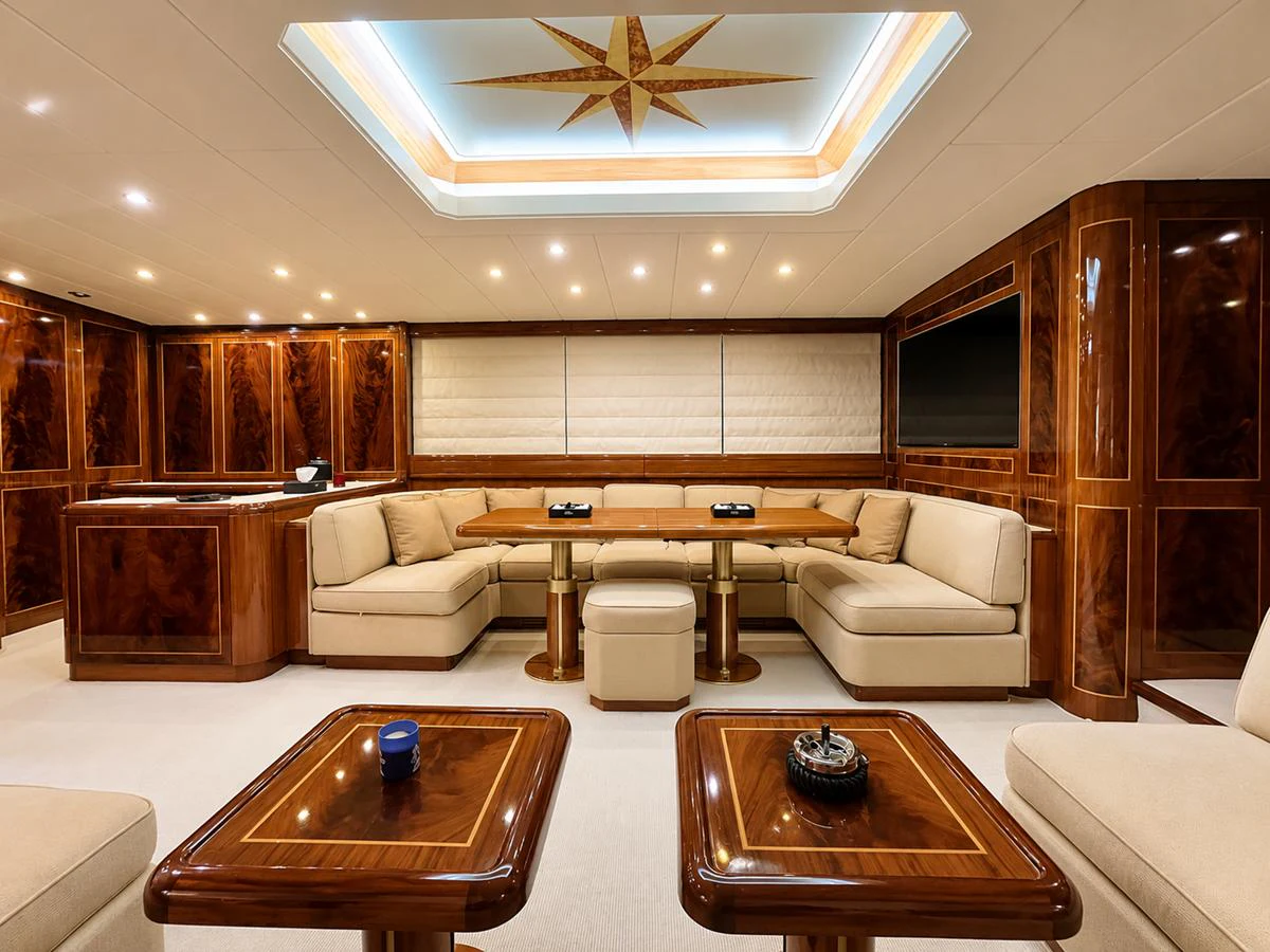 The salon features luxurious wood paneling, plush seating, and a sophisticated ceiling design. aboard ANGELINA Yacht for Sale