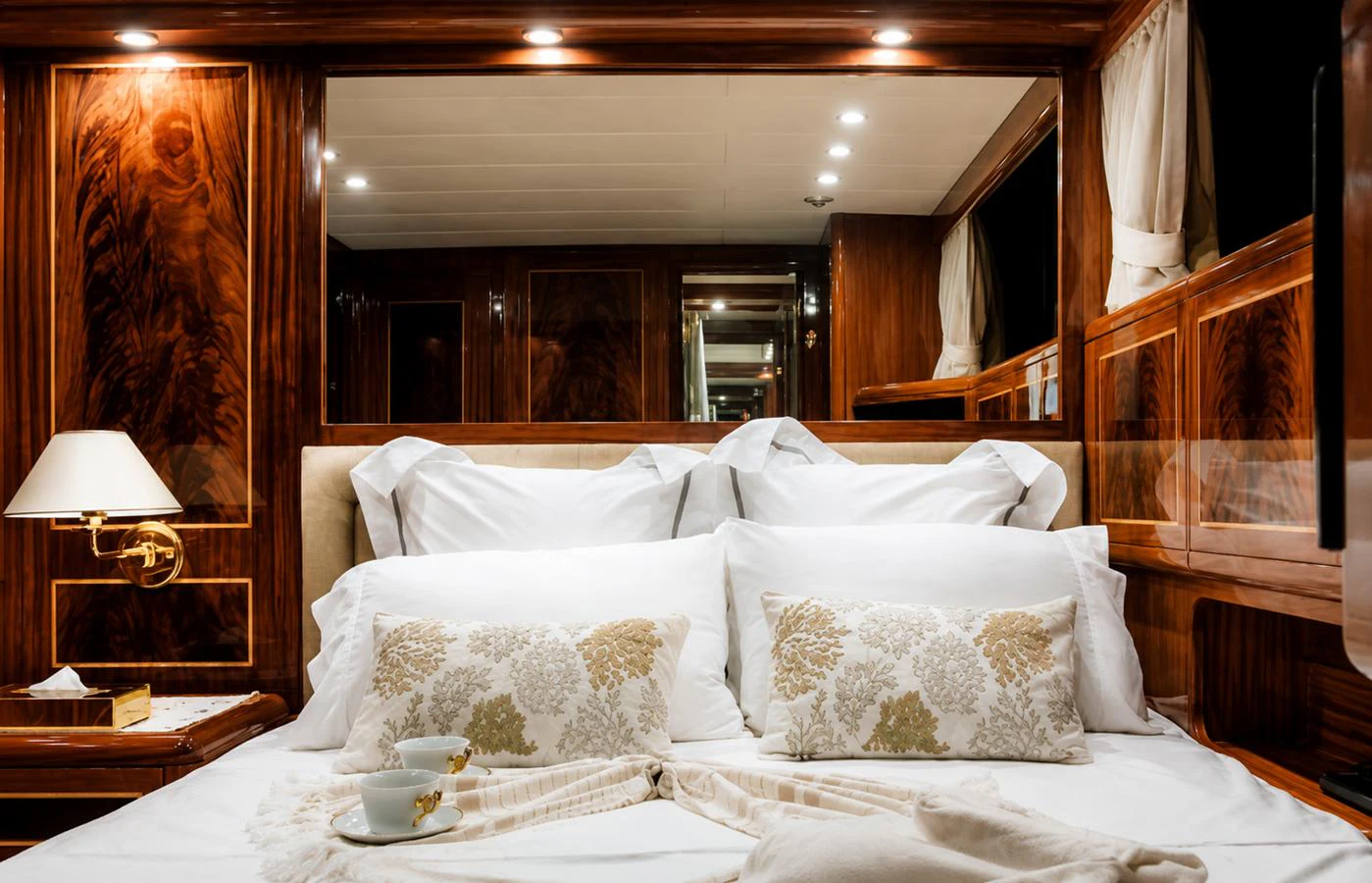 The stateroom features luxurious bedding and rich wood paneling, creating an inviting and elegant atmosphere. aboard ANGELINA Yacht for Sale