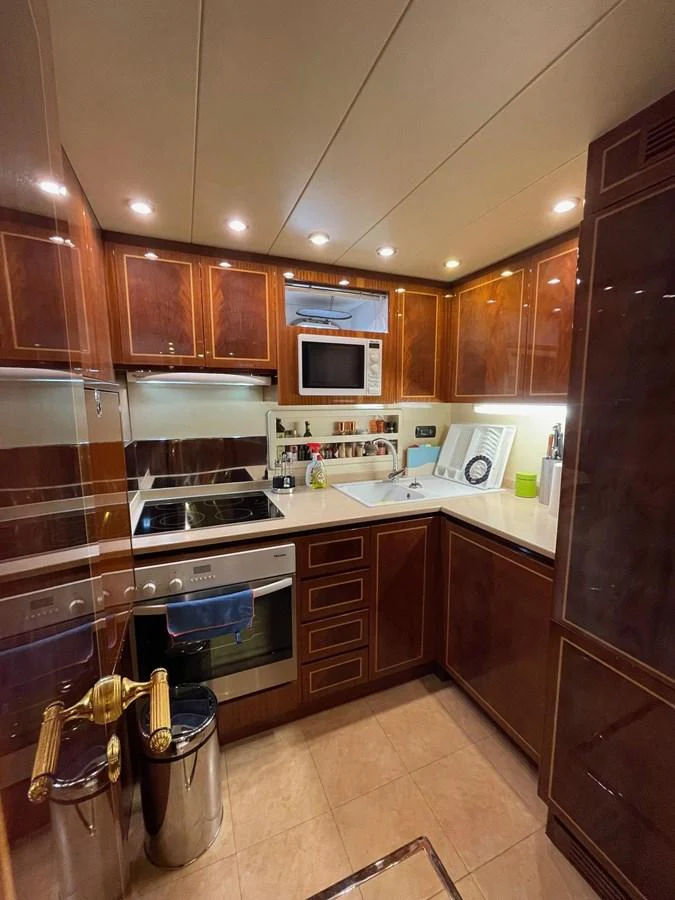 The yacht's galley is equipped with modern appliances and elegant wooden cabinetry, creating a warm and functional space for meal preparation. aboard ANGELINA Yacht for Sale