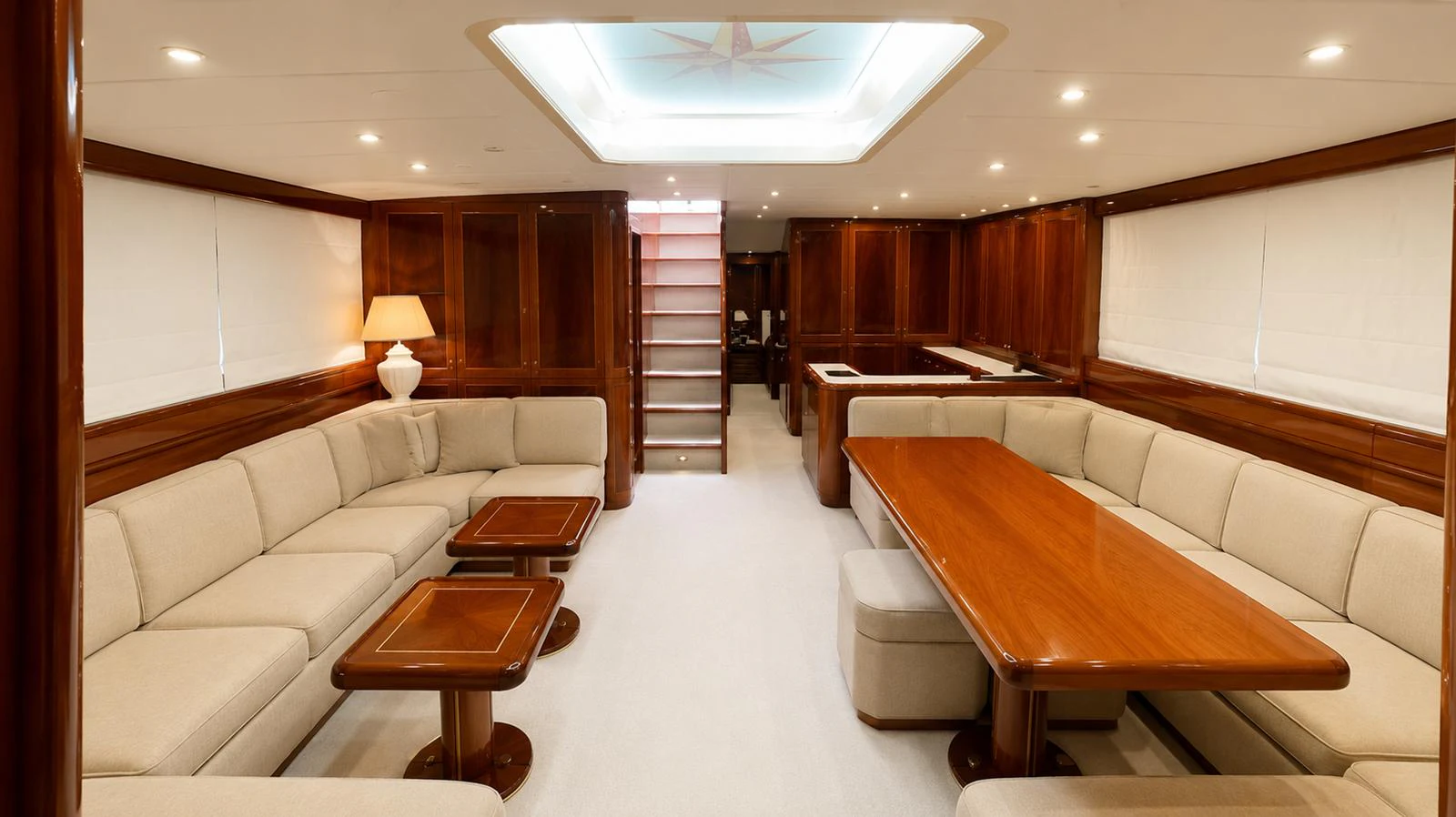 The yacht's salon features elegant wood finishes, plush seating, and a spacious dining area. aboard ANGELINA Yacht for Sale