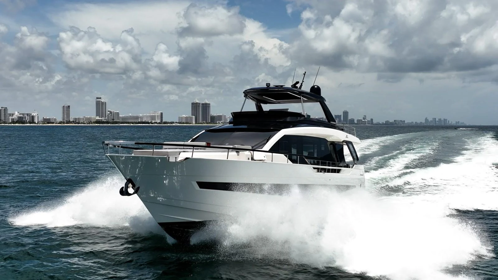 A sleek yacht cruises powerfully through the water, leaving a trail of white foam behind. aboard HOTEL COLLECTION Yacht for Sale
