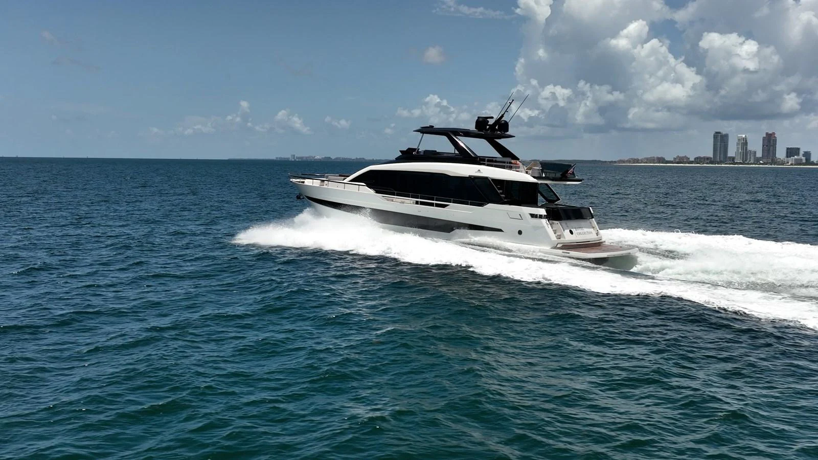 A sleek yacht cruises swiftly across the open sea under a partly cloudy sky. aboard HOTEL COLLECTION Yacht for Sale