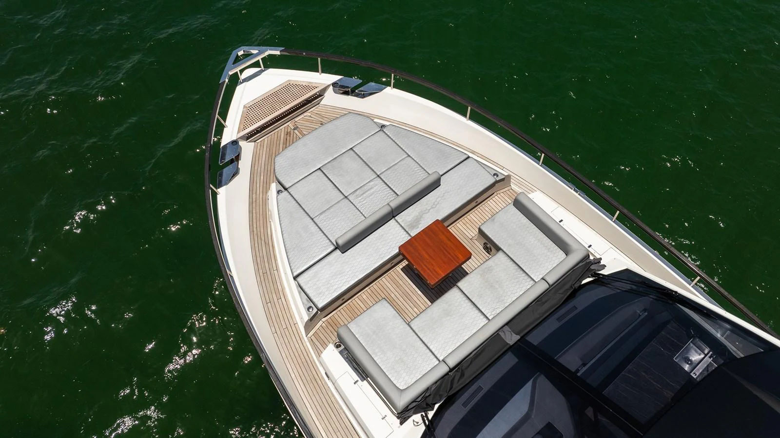 The yacht's foredeck features a spacious sunbathing area with comfortable cushions and a small wooden table, perfect for relaxation. aboard HOTEL COLLECTION Yacht for Sale