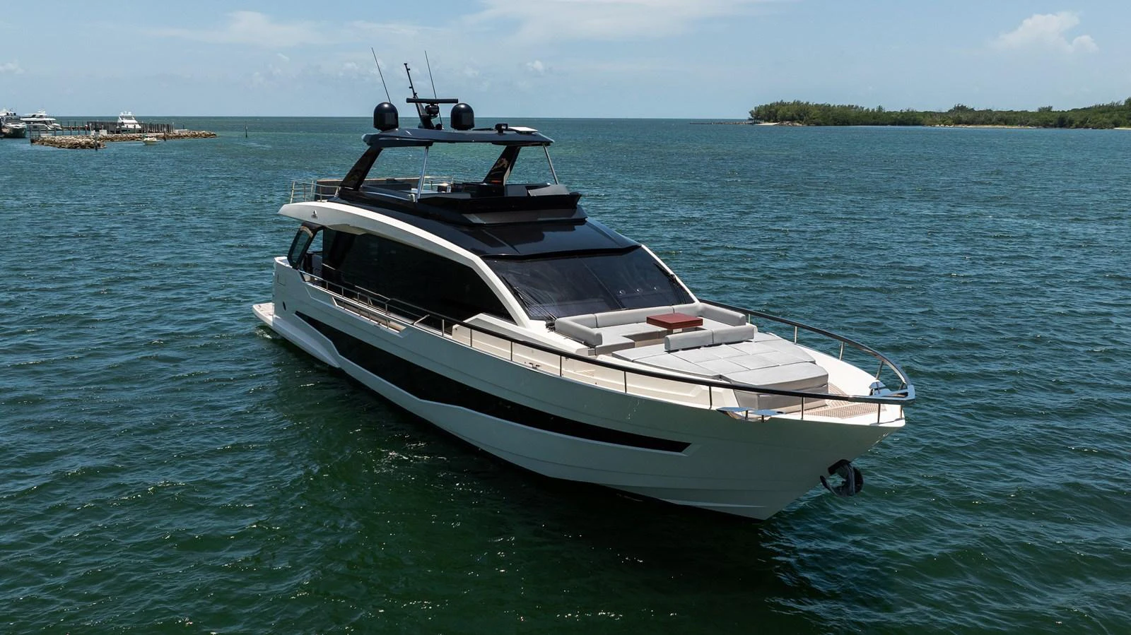 A sleek and modern yacht cruising on calm waters under a clear sky. aboard HOTEL COLLECTION Yacht for Sale