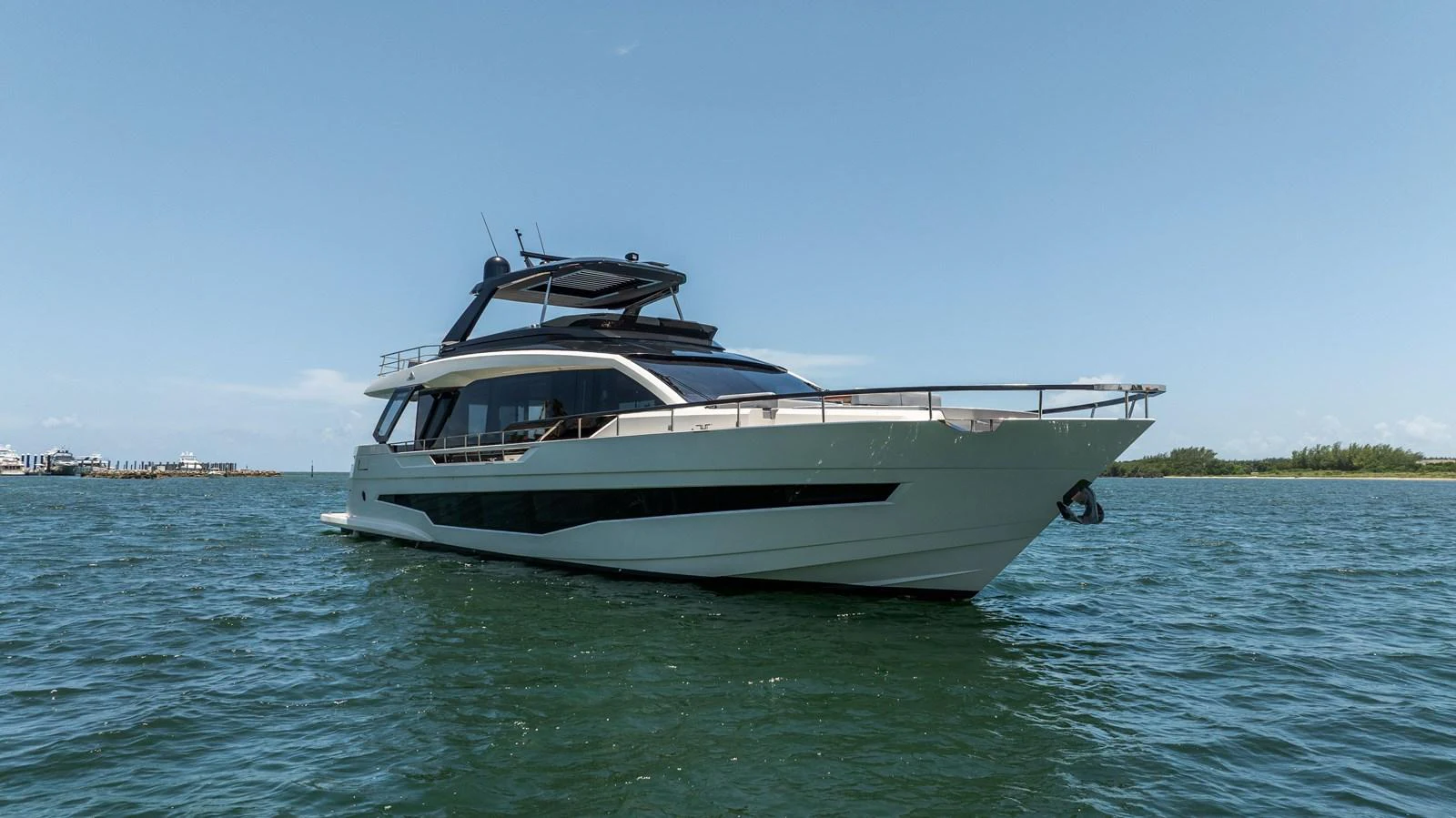 A sleek and modern yacht cruising on calm waters under a clear blue sky. aboard HOTEL COLLECTION Yacht for Sale