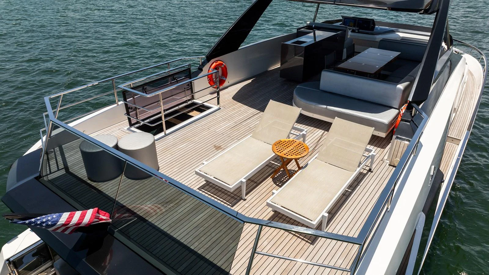 The yacht's aft deck features a spacious lounging area with sunbeds and a dining setup, perfect for relaxation and socializing. aboard HOTEL COLLECTION Yacht for Sale