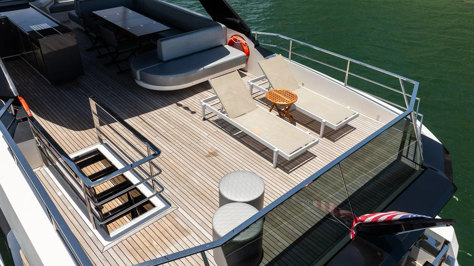 The sundeck features comfortable lounge chairs and a dining area, perfect for relaxation and socializing. aboard HOTEL COLLECTION Yacht for Sale