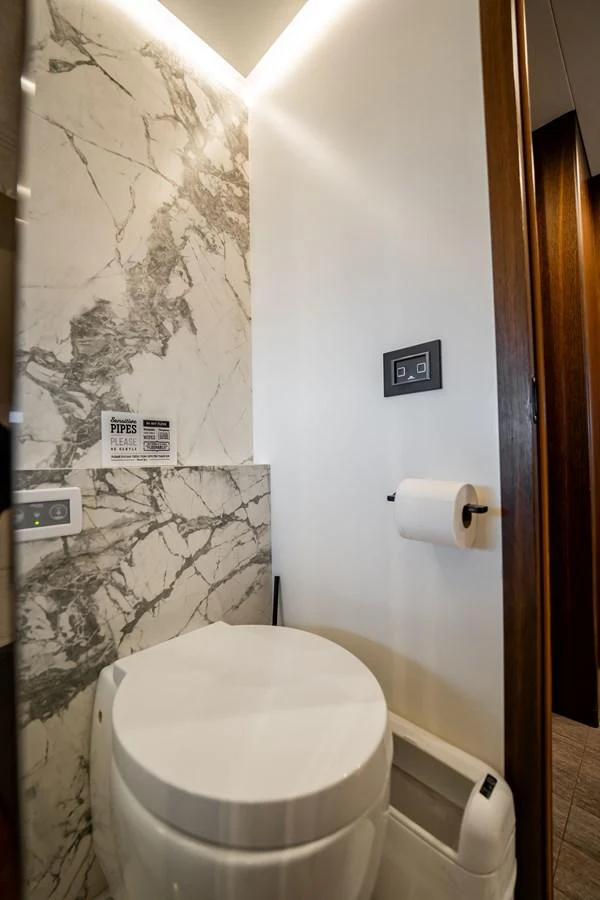 The yacht's head features a modern design with marble accents and sleek fixtures. aboard HOTEL COLLECTION Yacht for Sale