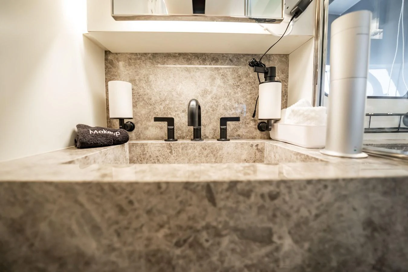 The yacht's bathroom features a sleek marble sink with modern fixtures. aboard HOTEL COLLECTION Yacht for Sale